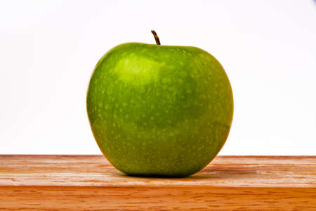 green apple on wood plateの写真素材