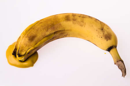 peeled banana with leaking yellow liquidの写真素材