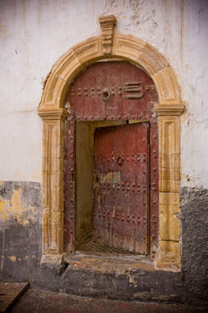 This old half-opened door, seen from a small Casablanca, Morocco street, is an invitation to mystery.の写真素材