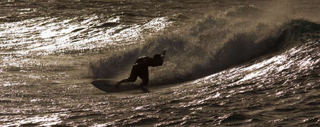 A surfer is riding a wave by sunset along beautiful Oahu, Hawaii North Shore
