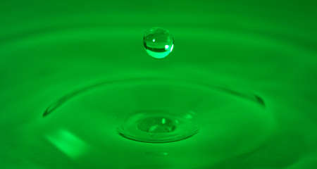 Drop of water captured with high speed macro photo with - Green gel filter- Shallow depth of field - Horizontalの写真素材