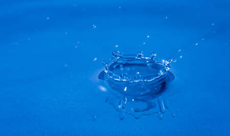 Splash of water captured with high speed macro photo - Blue gel filter - Shallow depth of field - Horizontalの写真素材