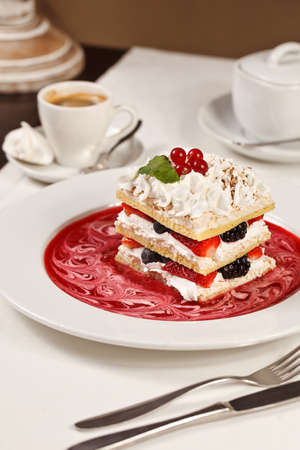 Appetizing french millefeuilles raspberry, blackberry, strawberry dessert with coffeeの写真素材