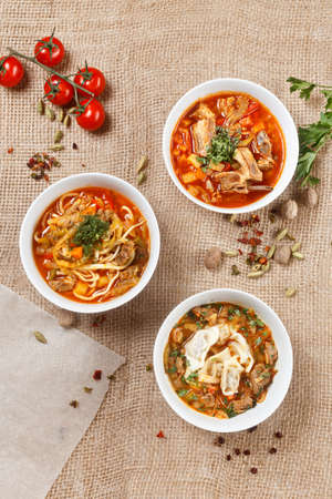 Shorba chuchvara soup national asian food in traditional bowls with spices and vegetables on canvas backgroung. uzbek georgian culture.の写真素材