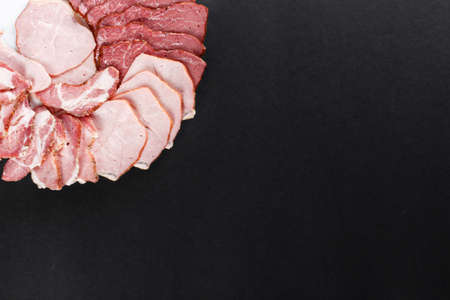 cutting ham assortment on black backgroundの写真素材