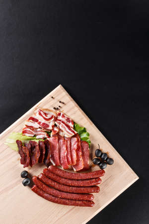 set of sausages with vegetables on cutting boardの写真素材