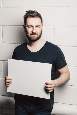 man with beard showing blank white cardの写真素材