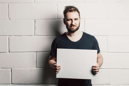 man with beard showing blank white cardの写真素材