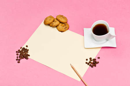 Mock-up template with white blank empty A4 sheet and cup of coffee on a color paper texture. Cake, coffee beans and biscuits on a table. Creative morning. Designer's breakfast.の写真素材