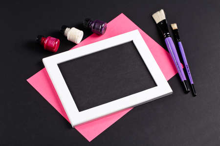 black and pink template with white photo frame on pink paper with brushes and gouache. Painter workplaceの写真素材