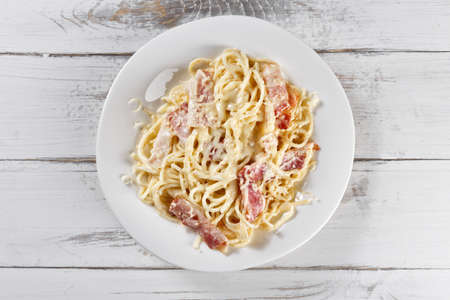 Fresh and beautiful fettuccine carbonara with bacon on wooden tableの写真素材