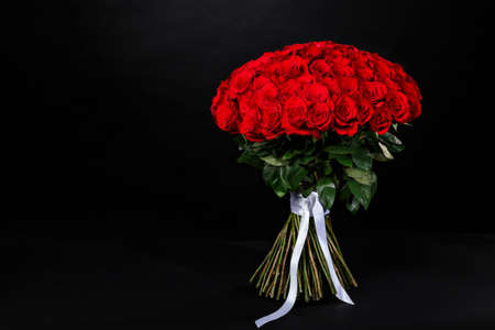 Romantic bouquet of red roses, place for the logo on a black studio background, spring is coming, 8 Marchの写真素材