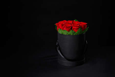 Romantic luxury red roses in a small black round gift box.