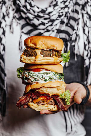 Three choices of tasty homemade burger. Healthy falafel burger with fresh lettuce, savory grilled chicken with fresh cut tomato, and meaty angus beef burger. Perfect choice for meat lovers and vegetarians.の写真素材