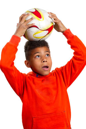 Boy with football ball. Little football player looks in the bright future. Football school for children.の写真素材