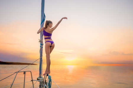 Recreation on the islands. Walk on the yacht near the islands. Romantic holiday on the water. Girl on a yacht on sunset background.の写真素材