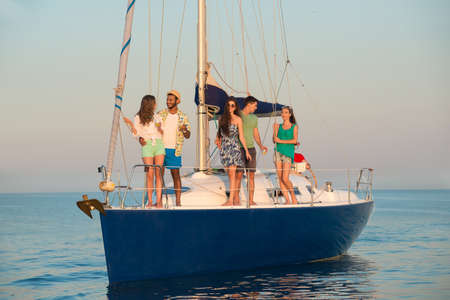 People on the yacht. Corporate party on a yacht. Merry Company is resting on a yacht. Young guys and girls are sailing on a yacht. Yacht voyage.の写真素材