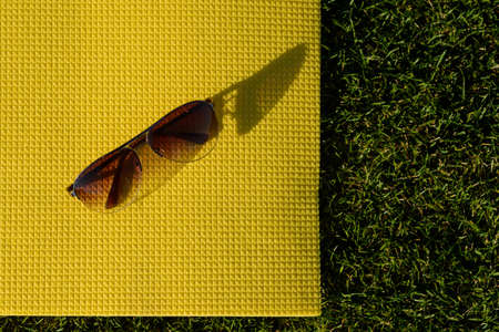 Sunglasses lying on a yoga mat Outdoor leisure. Accessories on the mat.の写真素材