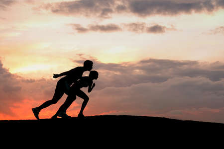 Athletes at the start. Silhouette of sportsmen ready to start. Athletes at sunset. Running sports.の写真素材