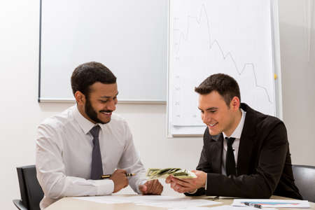 Ambitious managers count the income. Financial profit. Successful leaders.の写真素材