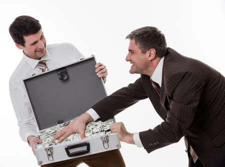 Businessmen divide profit. Clerks won the jackpot. Business people with suitcase full of money.の写真素材