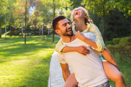 Guy and a girl having fun in the park. Lovers enjoy each other. Romantic date in a beautiful park.の写真素材