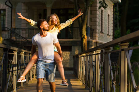 Guy and girl walking along the beautiful ranch. A romantic walk in the night park. Couple in love on the bridge.の写真素材