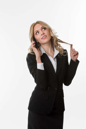 Cute girl flirts. Woman speaks on the phone with the guy. Beautiful blonde with the phone. Blonde in the office.の写真素材
