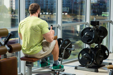 Strong man in gym. Bodybuilder training in gym. Bodybuilder building muscles. A sidewise picture of...