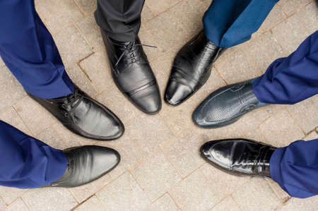 The groom's friends are showing their shoes.