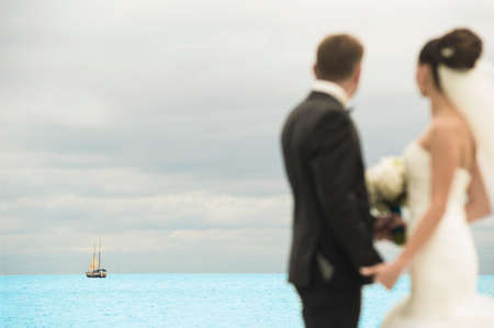 Newlyweds are standing on the pier. They are looking into the distance.の写真素材