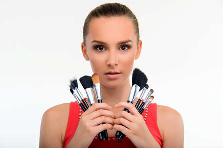 Visagiste with set of make-up brushes. Beautiful make-up artist looking at camera. Nice girl posing...