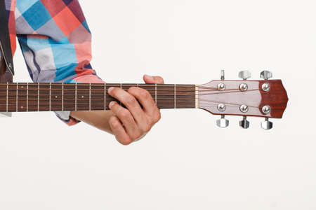 Fingerboard of guitar and hand playing guitar. Man's hand holding fingerboard. Picture of...