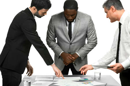 Three managers look at charts. Looking into fresh reports. Department chiefs' briefing. The task is clear.の写真素材