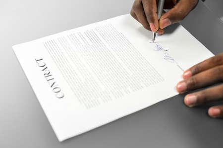 Afroamerican signs loan contract. Deciding to loan money. Gathering thoughts for decision. That's it.の写真素材