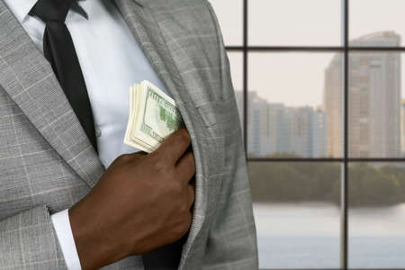 Darkskinned office employee hides salary. Afro office executive hiding money. City business brings...