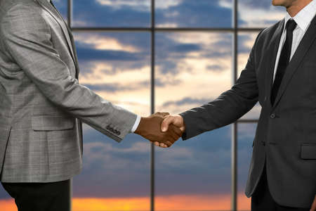 Politicians shake hands at sunset. Office handshake of two officials. Sunset meeting at conference...