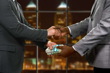 Two businessmen make money deal.の写真素材