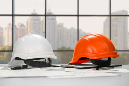 Safety inspector's helmets on office desk.の写真素材