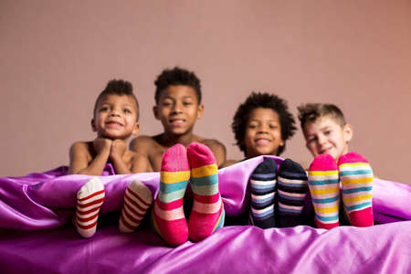 Happy boys in colorful socks. Cheerful boys sitting on bed. Cherish your friendship. When we were young.の写真素材