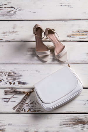 Small leather purse and footwear. Woman's shoes on old shelf. Accessory and footwear for ladies. Combination of shoes and purse.の写真素材
