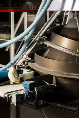 Bread moving on a conveyor belt. Mechanism for the production of bread. System of dough mixing.の写真素材