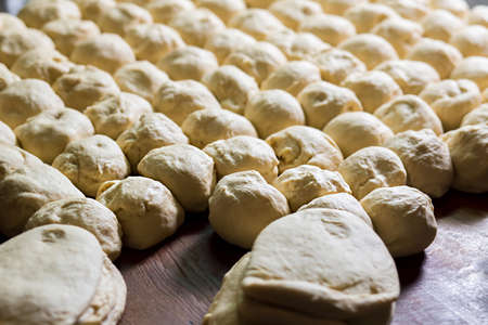 Yeast dough. Buns from dough. Dough rises on the table. Desserts making. Pies production. Baking buns. Flour products.の写真素材