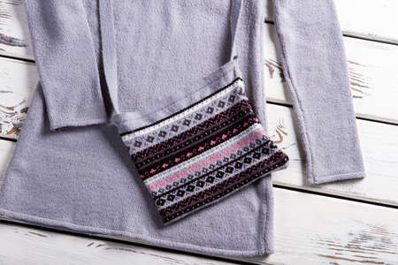 Woman's gray purse with sweater. Purse and sweater on showcase. Casual collection clothing on...