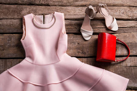Dress with necklace and purse. Evening garment on old shelf. Vintage store showcase with clothes. Combination of clothing and jewelry.の写真素材