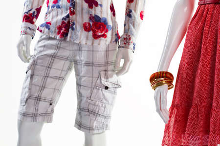 Shorts and dress on mannequins. Mannequins in light fashionable garments. Man's shorts and lady's sarafan. Checkered shorts and ripple dress.の写真素材