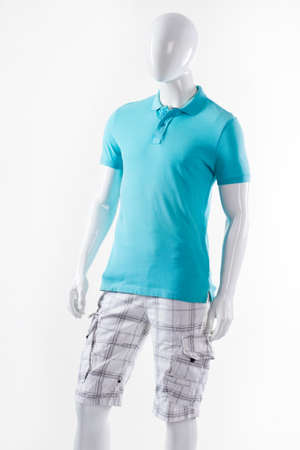 T-shirt and shorts on mannequin. Male mannequin wearing summer clothes. Blue t-shirt and white shorts. Cargo shorts with polo t-shirt.の写真素材