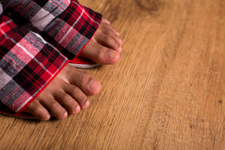 Afro kid's feet in slippers. Close-up of feet in slippers. Don't walk barefoot. Comfort and ease.の写真素材