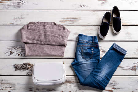 Jeans with sweatshirt and shoes. Young woman's outfit on showcase. Simple autumn clothes with handbag. Lady's clothing for spring.の写真素材