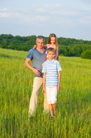 Dad with kids on a beautiful field. Family photo.